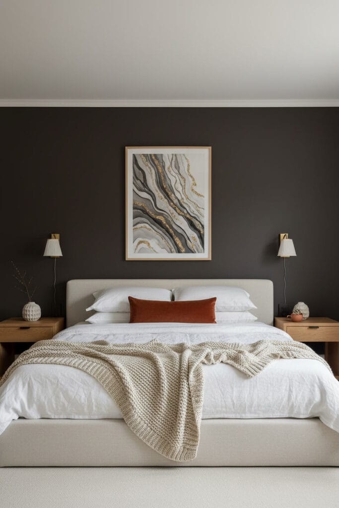 Grande chambre structurée par un mur d'accent brun charbon, murs clairs, lit en lin et bois clair.