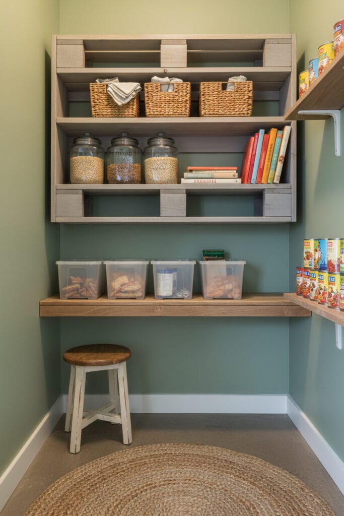 Petit cellier avec une étagère DIY en palette peinte, intégrée de manière harmonieuse parmi d'autres rangements.
