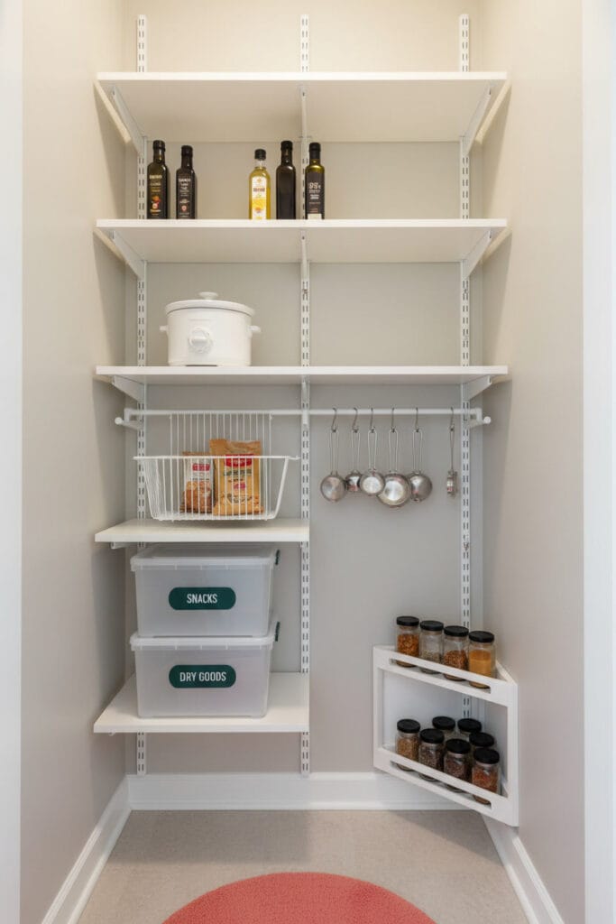 Cellier avec système d'étagères modulables blanc, rails métalliques et étagères ajustables pour bouteilles et accessoires.