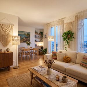Salon ouvert sur salle à manger décoré en macramé bohème avec suspension, coussins et rideaux
